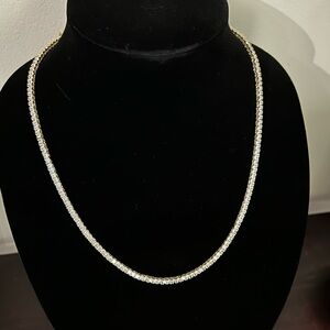 Gold tennis necklace with cross pendant